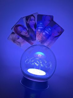 a glass ball with some pictures in it on top of a blue tableclothed surface