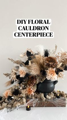 a black vase filled with dried flowers on top of a white table next to a sign that says diy floral cauldron centerpiece