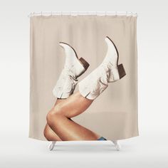 a woman's legs and shoes are shown in front of a shower curtain