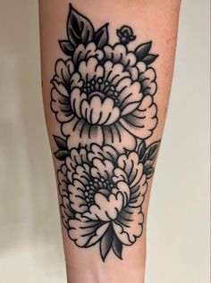 a black and white flower tattoo on the right leg, which is also in full bloom