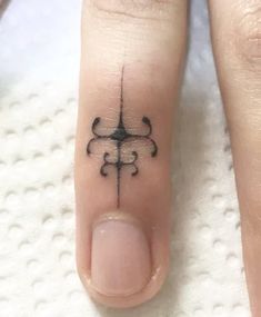 a woman's toe with a small tattoo design on her left thumb and the middle finger