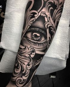 an all seeing eye tattoo on the forearm and arm is shown in black and grey