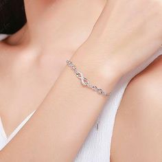 Upgrade your fine jewelry collection with this stunning Chain of Infinity bracelet. Crafted with love and care, this sterling silver bracelet features the timeless infinity symbol adorned with sparkling cubic zirconia gems. The platinum plating gives it a luxurious finish, ensuring long-lasting shine. Perfect as a gift for a loved one or a beautiful addition to your everyday wear. Materials: 925 sterling silver, cubic zirconiaFinish: platinum plateBracelet length: 6 + 2 inches. Jewelry Care: See Silver Infinity Bracelet With Adjustable Chain, White Gold Infinity Jewelry With Cubic Zirconia, White Gold Infinity Cubic Zirconia Jewelry, Elegant Infinity Chain Bracelet Adjustable, Silver Infinity Diamond Bracelet For Anniversary, Elegant Infinity Cubic Zirconia Jewelry, Elegant Infinity Chain Bracelet With Adjustable Chain, Sterling Silver Infinity Bracelets With Adjustable Chain, Sterling Silver Infinity Bracelet With Adjustable Chain