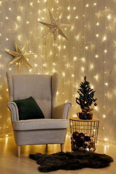 a chair and christmas tree in front of a wall with lights on the walls behind it