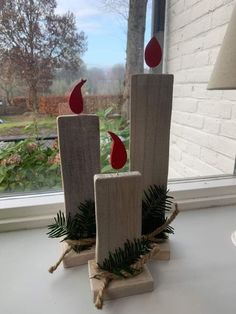 two wooden candles are sitting on a window sill