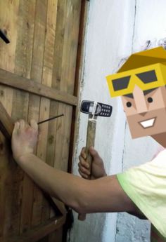 a man holding a hammer next to a wooden door with a cartoon character on it