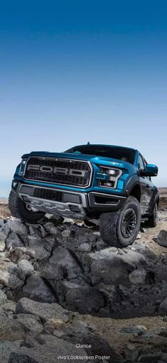 a blue truck is driving on some rocks