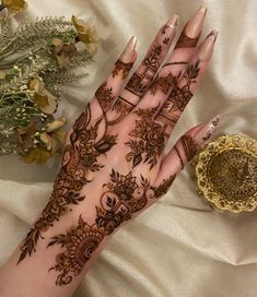 a woman's hand with henna tattoos on it