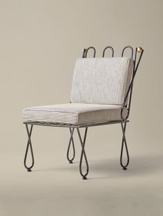 a white and black striped chair with two handles on the back, sitting in front of a gray background