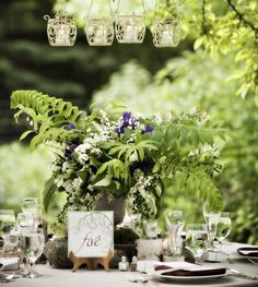 the table is set with place settings and centerpieces for an outdoor wedding reception