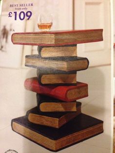 a stack of books sitting on top of each other in front of a glass vase