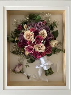 a bouquet of flowers in a white frame