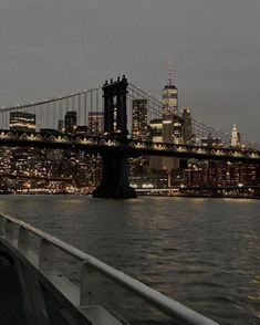 the city skyline is lit up at night as seen from a boat on the water