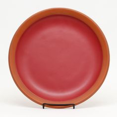 an orange and red plate sitting on top of a white table