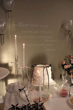 a table topped with cake and candles next to balloons