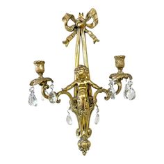 a gold chandelier with three lights and crystal drops on the bottom half of it