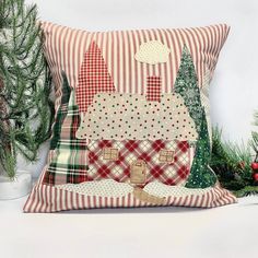 a decorative pillow is sitting next to a christmas tree