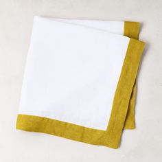 two yellow and white napkins sitting on top of each other