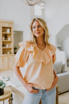 If you're looking for the perfect "date night" outfit, look no further! This gorgeous women's peach blouse is a beautiful blouse to pair with jeans or a skirt! Our Peach Ruffle Blouse is a v-neck blouse made with 100% Cotton. Elasticized on the neckline. It has short puff sleeves with elastic cuffs. Finished clean hem. Fits true to size. Available in women's sizes: Small Medium Large Peach V-neck Summer Blouse, Summer Peach V-neck Blouse, Elegant Apricot Summer Blouse, Elegant Summer Blouse In Apricot, Feminine V-neck Blouse For Brunch, Summer V-neck Peach Blouse, Chic Orange Ruffled Blouse, Chic Orange Blouse With Ruffles, Feminine Peach V-neck Blouse