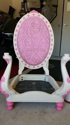 a pink and white chair sitting on top of a carpeted floor