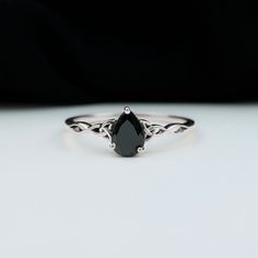 a black diamond ring sitting on top of a white table