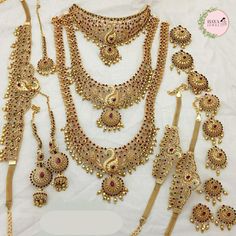 an assortment of necklaces and bracelets with gold colored beads on white cloth background