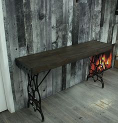 a wooden table sitting on top of a hard wood floor next to a fire place