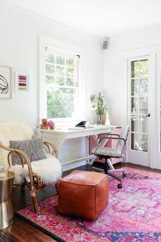 a living room with a chair, ottoman and rug