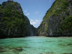 the water is crystal blue and clear with green trees on both sides in front of them