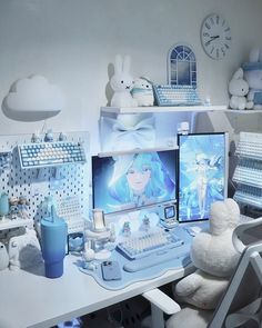 a white desk topped with two computer monitors next to a stuffed animal and other items