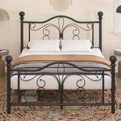 a black metal bed frame with white sheets and pillows on top of a rug in a bedroom