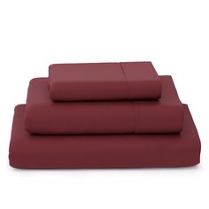 the sheet set is maroon and has four pillows on top of it, with one pillow in