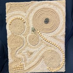 a piece of art that is made out of rope and yarn with circles on it