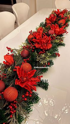 the table is decorated with red poinsettis and greenery