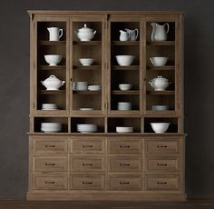 a wooden cabinet filled with lots of white dishes