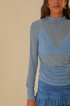 Indulge in a touch of elegance with our Blue Tulle Long Sleeved Blouse. Featuring a high neckline and long sleeves, this top adds a soft, playful sophistication to any outfit. Embrace a classic look with a modern twist with the clasp closure and solid print. Perfect for any occasion!Composition 93% POLYESTER 7% ELASTANE + 93% VISCOSE 7% ELASTANECare Instructions MACHINE WASH SEPARATELY, DO NOT BLEACH, DO NOT TUMBLE DRY, LINE DRYING, IRON AT LOW HEAT, DRY CLEAN WITH ANY SOLVENT EXCEPT TRICHLOROETHYLENESize and Fit Inches XXS XS S M L XL Bust 25 27 29 31 34 37 1/4 Waist 23 25 27 29 32 1/8 35 2/7 Length 20 1/3 21 21 1/2 22 22 2/3 23 1/4 Hip 26 28 30 32 38 1/4 38 1/4 Blue Sheer Top Outfit, Tulle Shirt Blouses, Sheer Top Outfit, Tulle Pants, Colorful Blouses, Colorful Crop Tops, Blue Tulle, Print Crop Tops, Blue Blouse