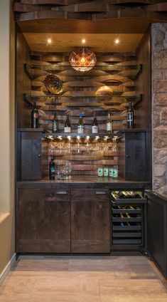 a wine cellar in the corner of a room with stone walls and wooden shelves filled with bottles