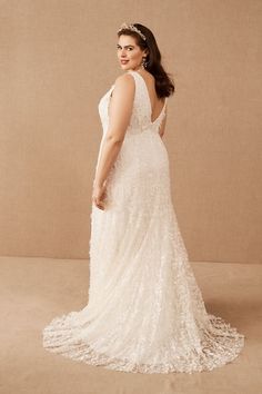 a woman in a white dress is standing with her back to the camera and looking off into the distance