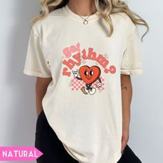 a woman wearing a white t - shirt with an image of a heart on it