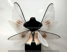 a black mannequin headdress with white wings