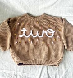 Personalized infant/toddler sweater. Sweater is an oversized chunky knit style. I recommend sizing down if you are between! Hand stitched with yarn and made to order exactly how you would like it! I can make it to match your little one's party theme or do sprinkles in their favorite colors. Message me if you would like to discuss designs! So cute for your little one or makes a perfect gift option❤️ If you have any questions or would like to discuss design options please send me a message! Cute Crew Neck Birthday Sweater, Cute Crew Neck Sweater For Birthday, Big Sister Announcement, Birthday Sweater, Pull Bebe, Sweater Chunky, Kids Jumpers, Toddler Sweater, Toddler Gift