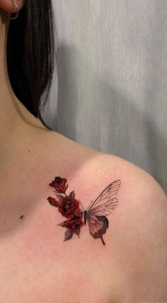 a woman's chest with red roses and a butterfly tattoo on her left shoulder