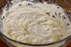 a glass bowl filled with batter on top of a wooden table