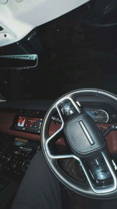 the interior of a car with steering wheel and dash board, dashboard controls, and other electronic devices