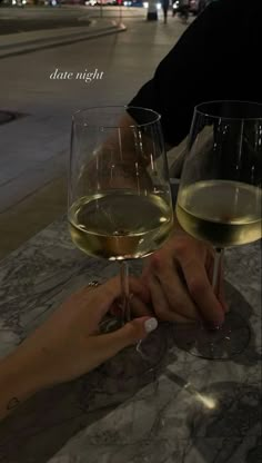 two glasses of wine are sitting on a table with the words date night written above them