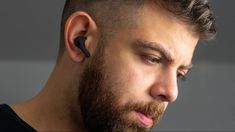 a man with a beard wearing an earbud