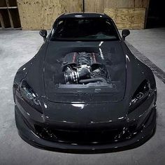 a black sports car with an engine in the hood