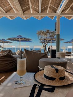 a straw hat sitting on top of a table next to an umbrella covered patio area