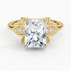 a yellow gold ring with a princess cut diamond