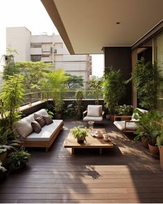 an outdoor living area with couches, tables and potted plants on the deck